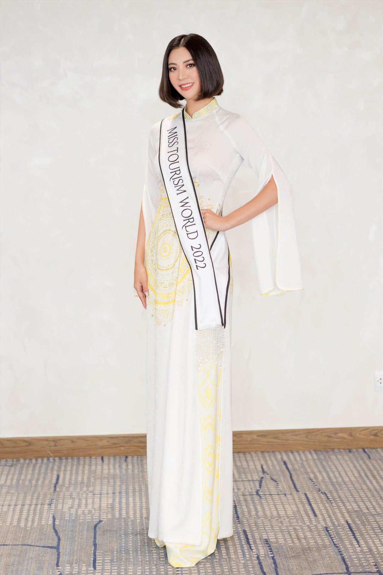 Hoa hậu Erina Hanawa người Nhật Bản tạo dáng với trang phục cách điệu xẻ ở hai tay áo, họa tiết đậm phong cách Việt.  Erina Hanawa sinh năm 1994, cao 1,72 m, số đo 3 vòng là 97-68-98 cm. Cô từng đoạt Á hậu 1 cuộc thi Hoa hậu Trái đất Nhật Bản 2020.